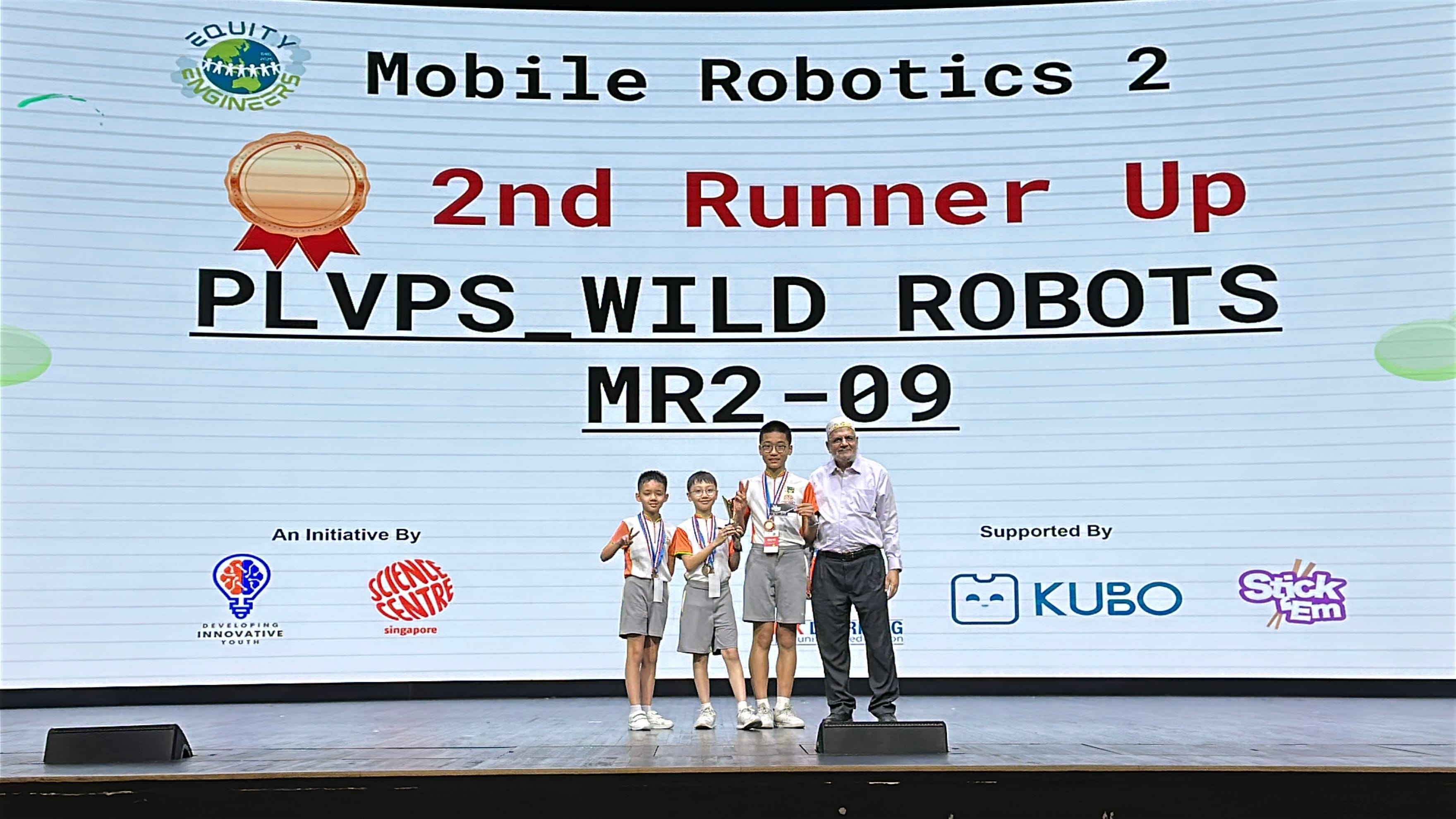 3 robotics club students receiving an award on stage